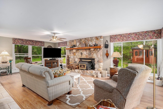 731 13 Mile Rd NW, Sparta, MI 49345 - living room with plenty of natural light, a ceiling fan, a wood stove, and light wood finished floors
