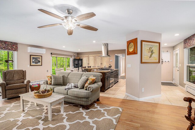 731 13 Mile Rd NW, Sparta, MI 49345 - living area with a wall mounted air conditioner, a ceiling fan, recessed lighting, baseboard heating, and light wood-style flooring