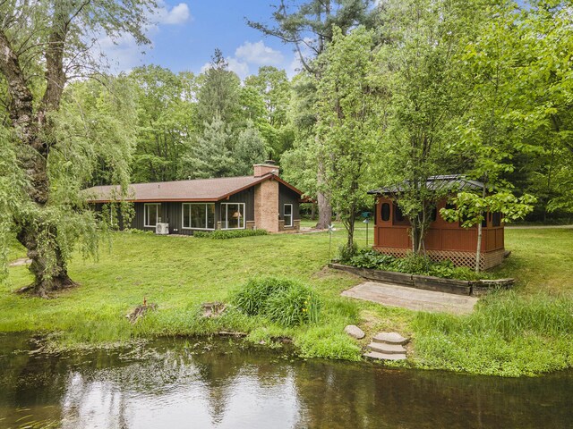 731 13 Mile Rd NW, Sparta, MI 49345 - rear view of property featuring a chimney, a lawn, and a water view