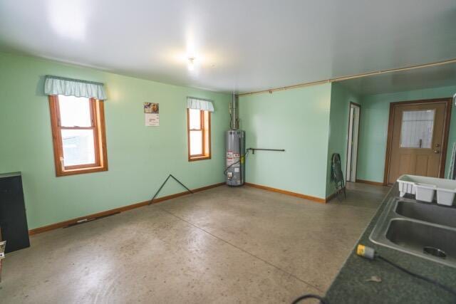 14656 Hersey Rd, Hersey, MI 49639 - unfurnished room with water heater, baseboards, a sink, and speckled floor