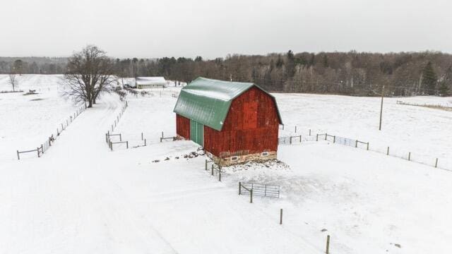 14656 Hersey Rd, Hersey, MI 49639 - snowy yard with a barn, a detached garage, and an outdoor structure