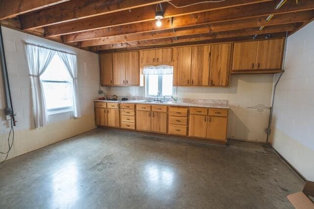 14656 Hersey Rd, Hersey, MI 49639 - kitchen with light countertops, concrete block wall, a sink, and brown cabinets
