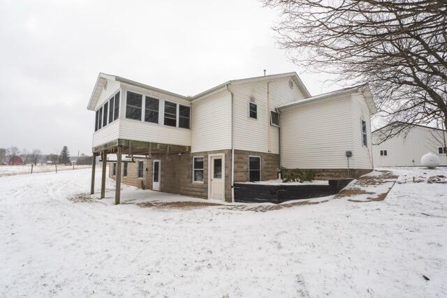 14656 Hersey Rd, Hersey, MI 49639 - snow covered rear of property with a sunroom