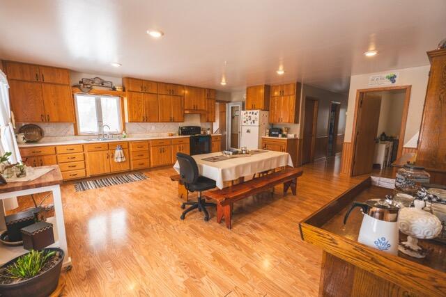 14656 Hersey Rd, Hersey, MI 49639 - kitchen with freestanding refrigerator, stove, light countertops, light wood finished floors, and brown cabinets