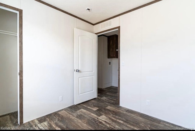16196 Notre Dame, Clinton Township, MI 48038 - unfurnished bedroom with dark wood-style floors, ornamental molding, and a closet