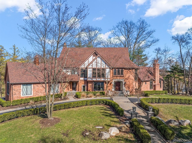 3013 Heron Pl, Bloomfield Hills, MI 48302 - tudor home with brick siding, a front lawn, and a chimney