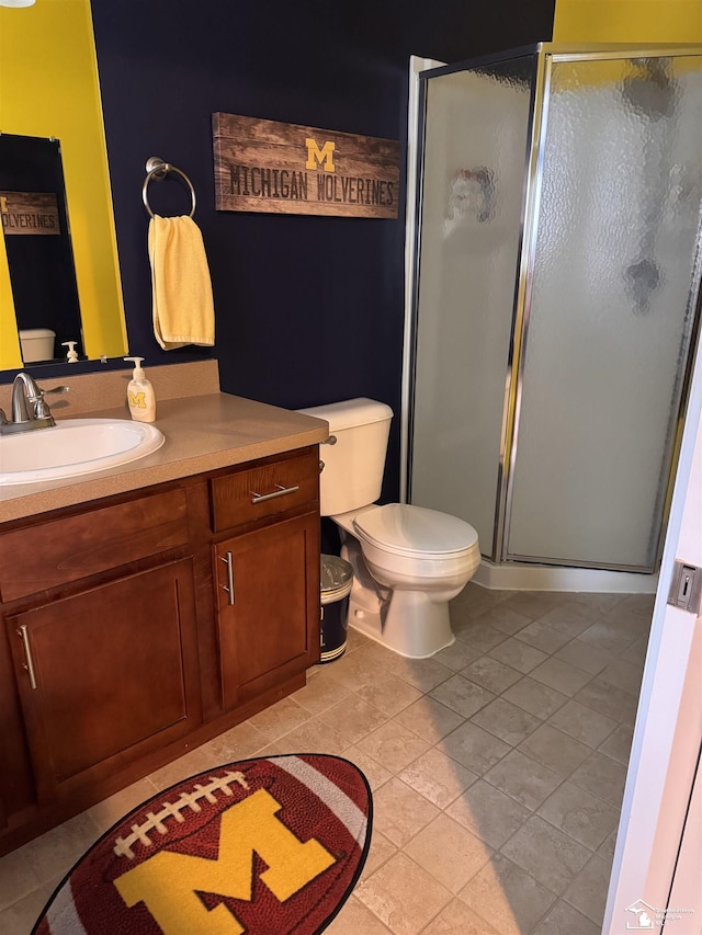 2446 8th St, Wyandotte, MI 48192 - bathroom featuring toilet, vanity, a stall shower, and tile patterned flooring