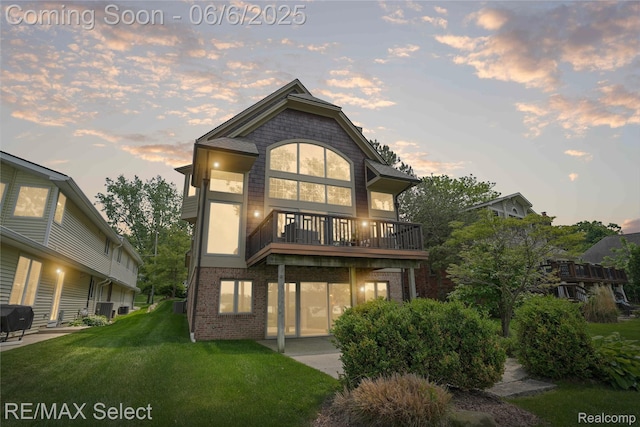 15496 Bealfred Dr, Fenton, MI 48430 - back of property at dusk featuring a patio, a yard, and brick siding