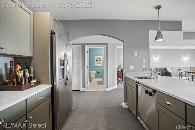 15496 Bealfred Dr, Fenton, MI 48430 - kitchen with stainless steel appliances, arched walkways, a sink, dark carpet, and decorative light fixtures