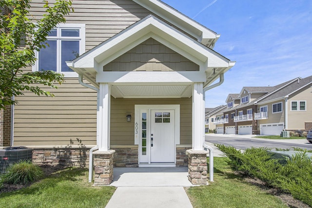 603 Woodland, Dexter, MI 48130 - doorway to property with central AC, covered porch, stone siding, and a residential view