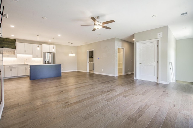 603 Woodland, Dexter, MI 48130 - unfurnished living room featuring ceiling fan, wood finished floors, baseboards, recessed lighting, and a sink
