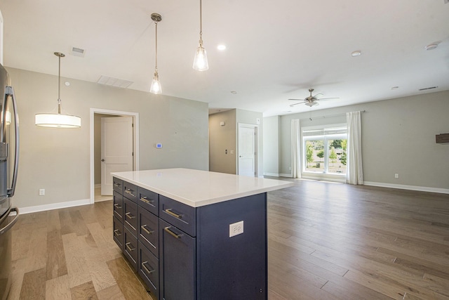 603 Woodland, Dexter, MI 48130 - kitchen featuring ceiling fan, wood finished floors, a center island, open floor plan, and light countertops