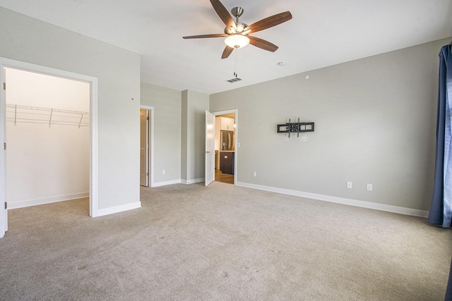 603 Woodland, Dexter, MI 48130 - unfurnished bedroom with light colored carpet, baseboards, a walk in closet, ceiling fan, and a closet