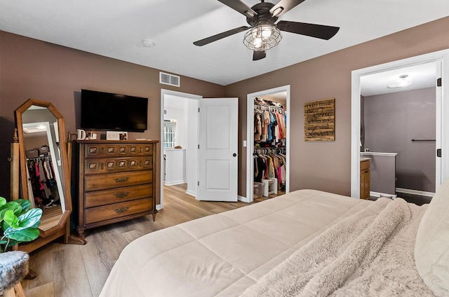 5855 Larson Ln, Muskegon, MI 49444 - bedroom featuring a walk in closet, a closet, wood finished floors, baseboards, and ensuite bathroom