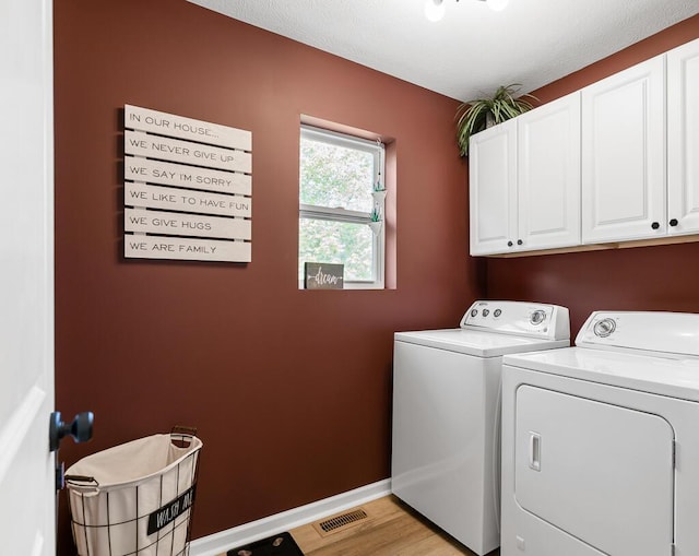 5855 Larson Ln, Muskegon, MI 49444 - washroom featuring cabinet space, independent washer and dryer, baseboards, and light wood-type flooring