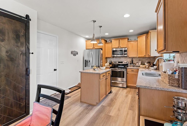 5855 Larson Ln, Muskegon, MI 49444 - kitchen with stainless steel appliances, a sink, light wood-type flooring, recessed lighting, and a kitchen island