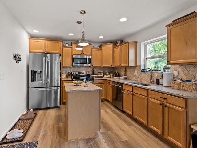5855 Larson Ln, Muskegon, MI 49444 - kitchen featuring appliances with stainless steel finishes, a sink, a kitchen island, light wood-style floors, and recessed lighting