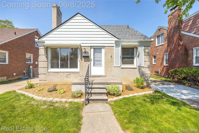 21167 Lancaster St, Grosse Pointe Woods, MI 48225 - bungalow-style house featuring brick siding, a front lawn, a chimney, and a shingled roof