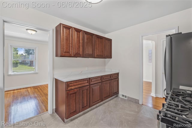 21167 Lancaster St, Grosse Pointe Woods, MI 48225 - kitchen featuring freestanding refrigerator, baseboards, and light stone countertops