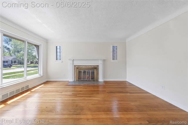 21167 Lancaster St, Grosse Pointe Woods, MI 48225 - unfurnished living room with a textured ceiling, wood finished floors, a premium fireplace, and baseboards