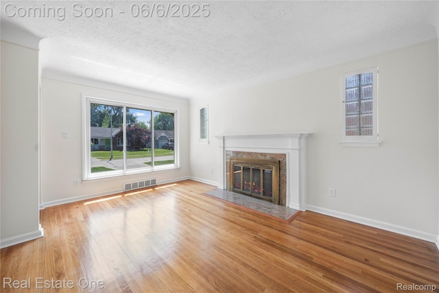 21167 Lancaster St, Grosse Pointe Woods, MI 48225 - unfurnished living room with wood finished floors, a textured ceiling, a fireplace, and baseboards