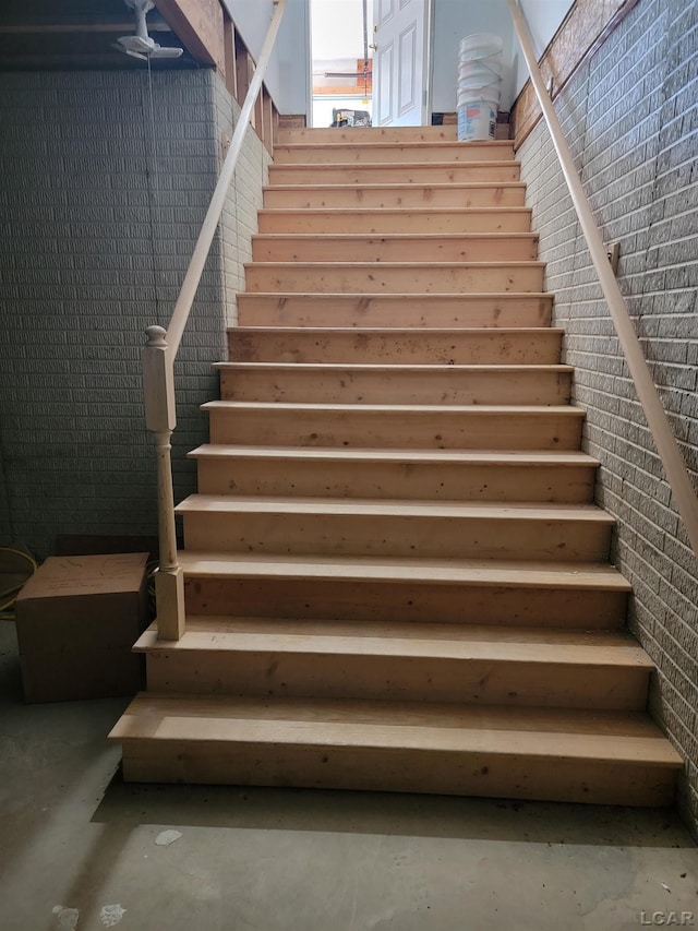 1577 Benner Hwy, Clayton, MI 49235 - staircase with concrete floors and brick wall