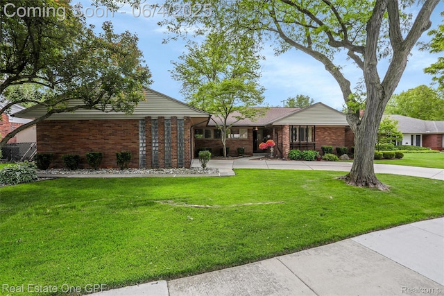439 Barclay Rd, Grosse Pointe Farms, MI 48236 - view of front of home with brick siding, a front lawn, and curved driveway