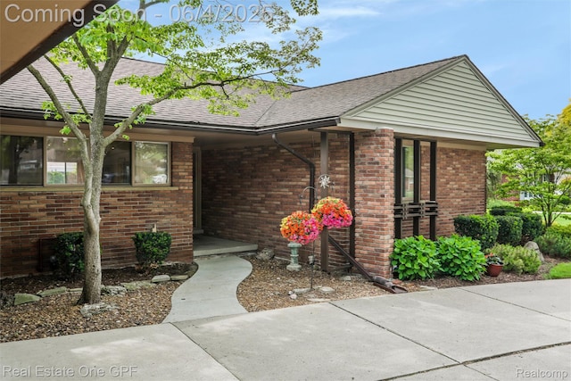 439 Barclay Rd, Grosse Pointe Farms, MI 48236 - view of exterior entry featuring brick siding and roof with shingles