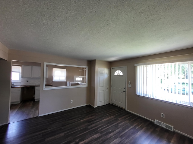 13753 Mcguire St, Taylor, MI 48180 - entrance foyer with a textured ceiling, dark wood finished floors, and baseboards
