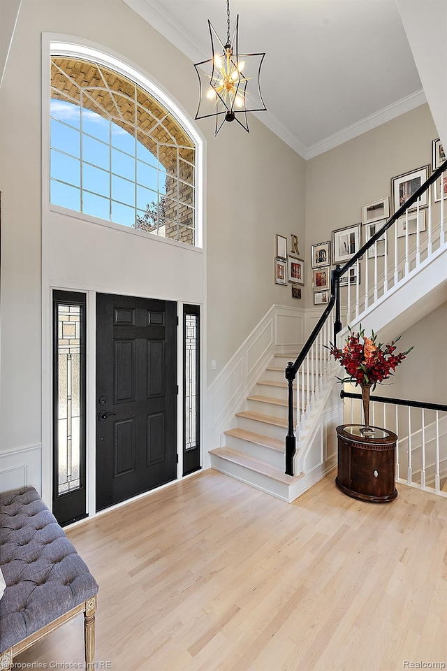 1707 Mountain Ash Dr, West Bloomfield, MI 48324 - foyer entrance featuring a towering ceiling, wood finished floors, a chandelier, stairs, and a decorative wall
