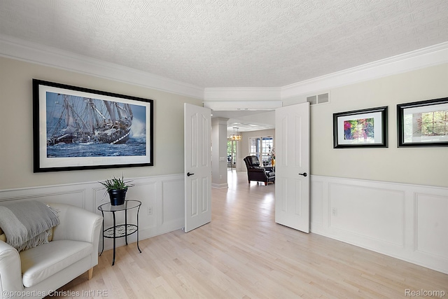 1707 Mountain Ash Dr, West Bloomfield, MI 48324 - corridor featuring a textured ceiling, crown molding, a decorative wall, light wood finished floors, and decorative columns
