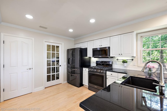 1707 Mountain Ash Dr, West Bloomfield, MI 48324 - kitchen with stainless steel gas range, black refrigerator with ice dispenser, dark countertops, light wood finished floors, and white cabinets