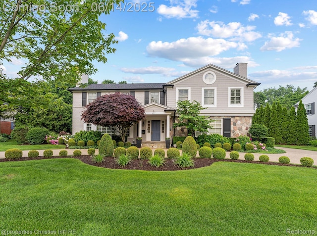 457 N Cranbrook Rd, Bloomfield Hills, MI 48301 - view of front of property with stone siding, a front lawn, and a chimney