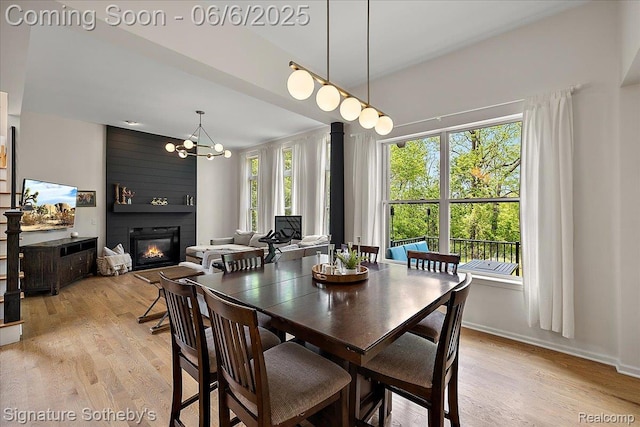 871 Wynstone Cir S, Oakland, MI 48363 - dining room with a large fireplace, light wood finished floors, a chandelier, and baseboards