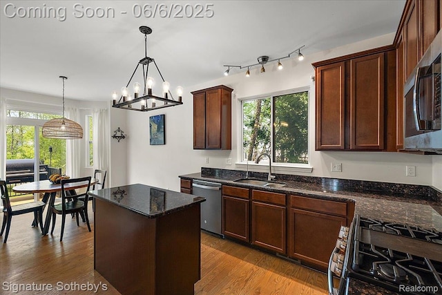 871 Wynstone Cir S, Oakland, MI 48363 - kitchen featuring appliances with stainless steel finishes, a sink, wood finished floors, dark stone counters, and hanging light fixtures
