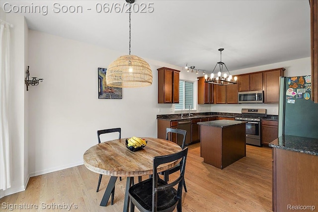 871 Wynstone Cir S, Oakland, MI 48363 - kitchen featuring stainless steel appliances, a kitchen island, light wood finished floors, a chandelier, and pendant lighting