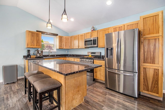 69698 Fox Xing, Edwardsburg, MI 49112 - kitchen featuring appliances with stainless steel finishes, lofted ceiling, a sink, a breakfast bar area, and a kitchen island