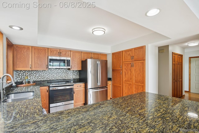 2734 Silverside Rd, Waterford, MI 48328 - kitchen featuring stainless steel appliances, a sink, decorative backsplash, brown cabinets, and recessed lighting