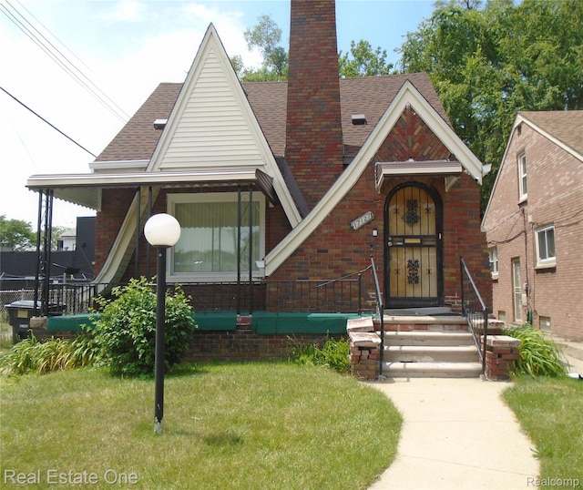 17127 Griggs St, Detroit, MI 48221 - view of front of home with a chimney, a shingled roof, a front lawn, and brick siding
