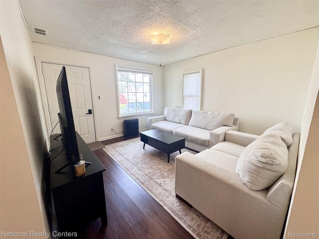 5689 Cornell St, Dearborn Heights, MI 48125 - living room featuring dark wood-type flooring, a textured ceiling, and baseboards