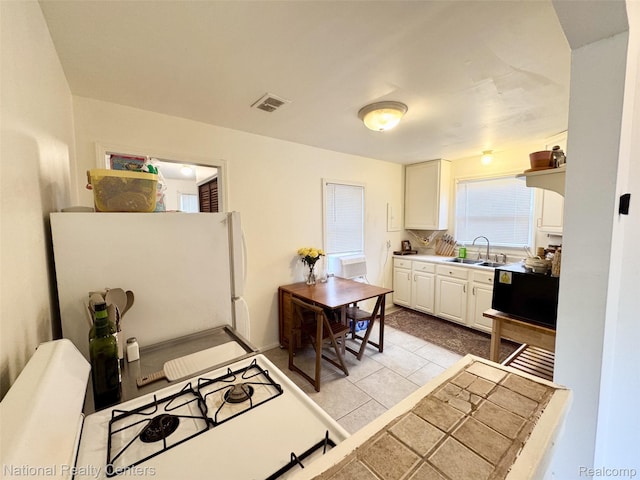 5689 Cornell St, Dearborn Heights, MI 48125 - kitchen featuring white appliances, a sink, white cabinets, and light tile patterned floors