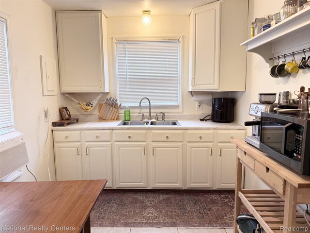 5689 Cornell St, Dearborn Heights, MI 48125 - kitchen featuring a sink, stainless steel microwave, white cabinets, and light countertops