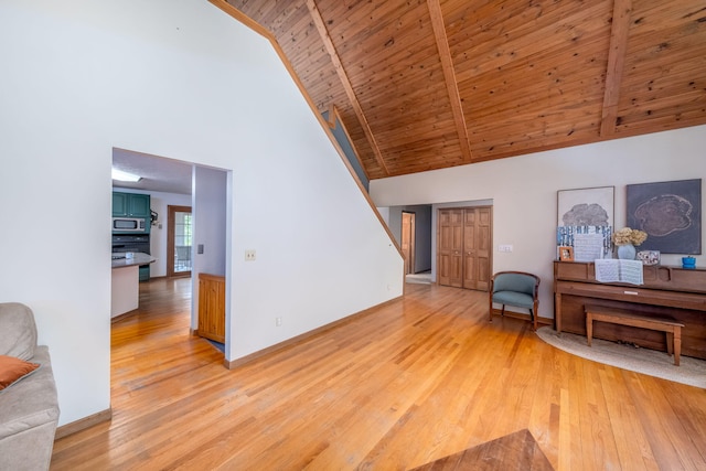 4300 Holton-Duck Lake Rd, Twin Lake, MI 49457 - living room featuring high vaulted ceiling, light wood-type flooring, wood ceiling with exposed beams, and baseboards