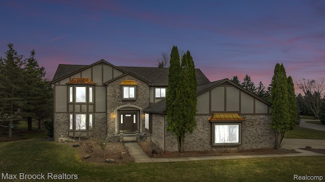 4070 Greenbriar Ct, Rochester, MI 48306 - tudor-style house featuring stucco siding, a front yard, and roof with shingles