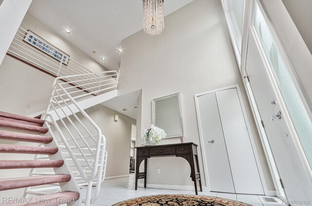 2337 Horseshoe Dr, West Bloomfield, MI 48322 - stairway with a high ceiling, tile patterned floors, baseboards, and a chandelier
