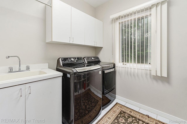 2337 Horseshoe Dr, West Bloomfield, MI 48322 - laundry area with washing machine and dryer, cabinet space, baseboards, and light tile patterned flooring
