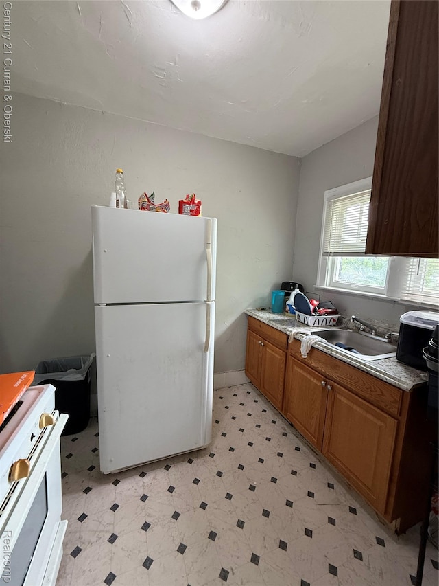 11647 Cascade St, Detroit, MI 48204 - kitchen with white appliances, a sink, light floors, and brown cabinets