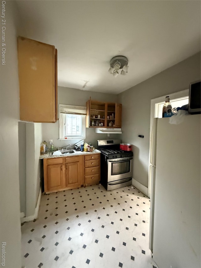 11647 Cascade St, Detroit, MI 48204 - kitchen featuring stainless steel range with gas stovetop, freestanding refrigerator, light floors, a sink, and baseboards