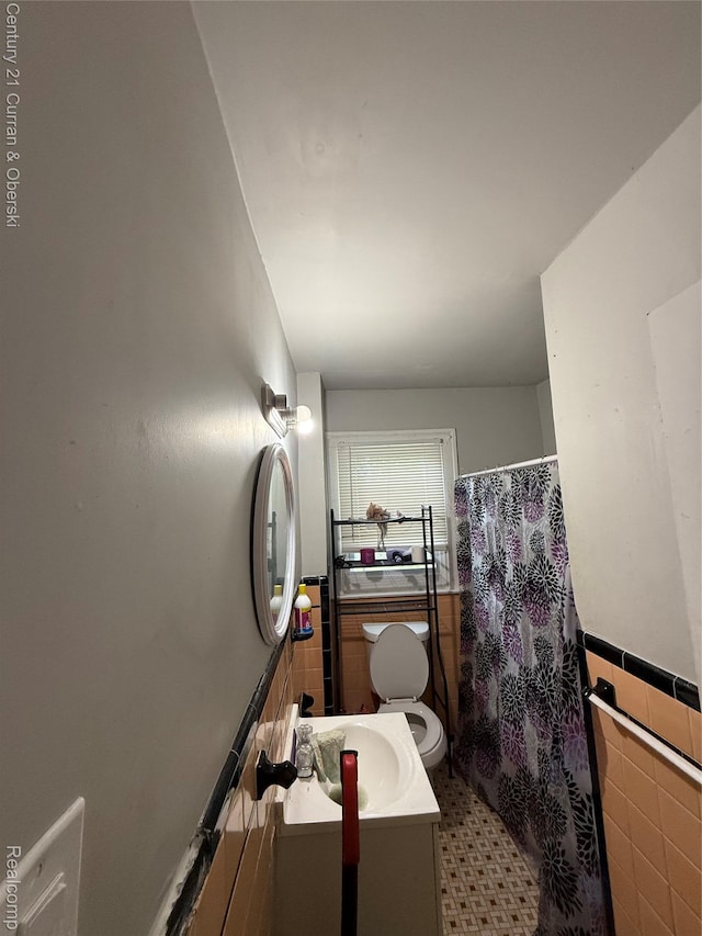 11647 Cascade St, Detroit, MI 48204 - full bathroom with tile walls, vanity, toilet, wainscoting, and a shower with shower curtain