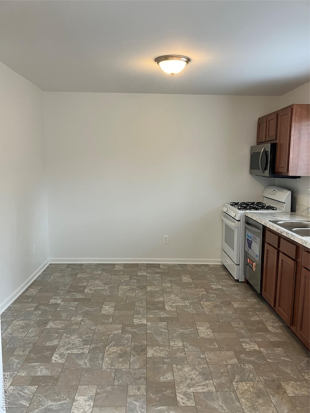 20747 Washington Dr, Roseville, MI 48066 - kitchen with appliances with stainless steel finishes, baseboards, light countertops, and a sink